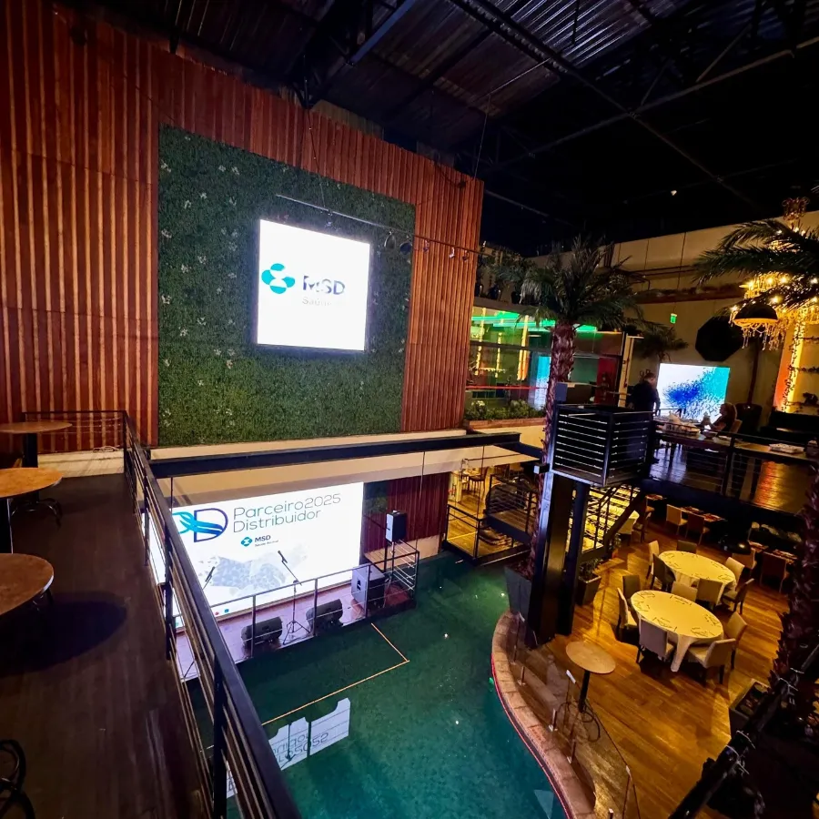 Cenografia com parede verde e telão em evento corporativo